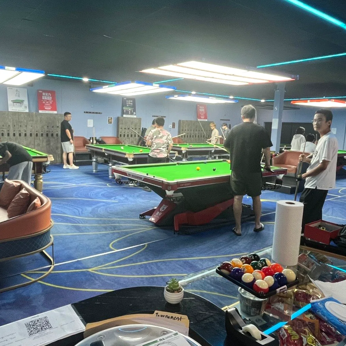 Cue Action billiards room with players and multiple tables